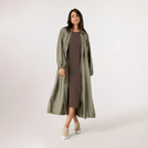 A model wearing a seasonal rainforest zip front parka over a brown dress - عارضة أزياء ترتدي سترة باركا بسحاب أمامي فوق فستان بني